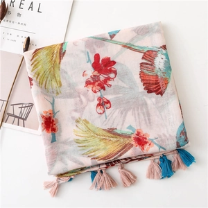 Detail of pink floral sun shawl with colorful bird prints and tassel fringe edges