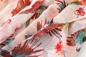 Close-up of tropical bird and floral print on breathable light pink cotton linen scarf