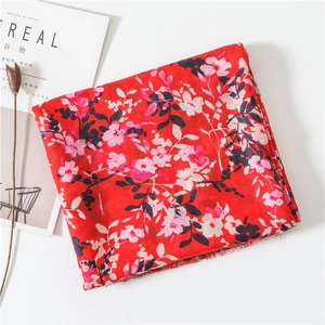 Detailed view of red floral cotton linen scarf with tassels and pink flower patterns
