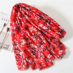Detail of red floral cotton linen scarf with fine tassel edges and ethnic print design