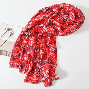 Detail of red floral cotton linen scarf with soft fringe edges and retro ethnic print