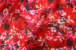 Close-up of red cotton linen scarf with floral print and soft fabric texture details