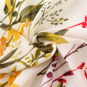 Macro shot of floral pattern on cotton linen fabric with yellow blossoms and green leaves