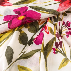 Macro detail of floral linen cotton scarf fabric with vibrant pink flowers and green leaves