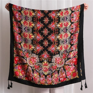 Detail view of large black floral scarf with Russian folk patterns and tassel edges