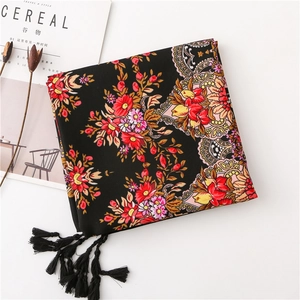 Close-up of black floral scarf with colorful patterns and elegant black corner tassels
