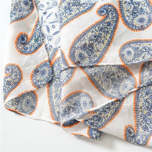 Macro detail of navy and orange paisley print scarf with soft cotton-feel fabric texture