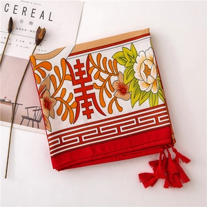 Detail of Chinese style floral cotton scarf with red tassels and longevity motif