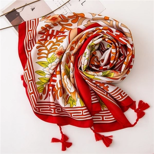 Detailed view of red and white cotton linen scarf with floral print and red corner tassels