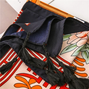 Detail of floral print silk shawl with orange flowers and black woven fringe tassels