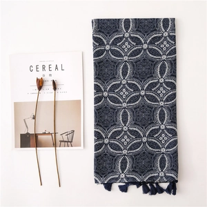 Écharpe vintage en lin bleu marine avec motifs floraux et pompons sur fond blanc