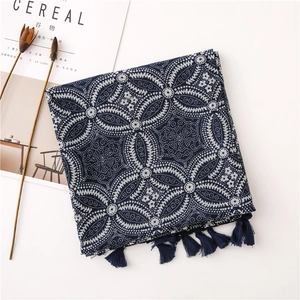 Vue détaillée du motif mandala vintage et des glands sur l'écharpe en coton bleu marine