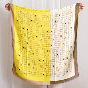 Détail d'une grande écharpe en coton et lin avec carreaux jaunes et bords effilochés