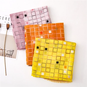 Détail de foulards à carreaux en coton et lin roses, oranges et jaunes avec bords effilochés