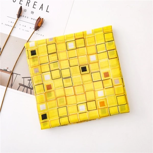 Gros plan détaillé du motif à carreaux jaunes sur une écharpe douce en coton et lin