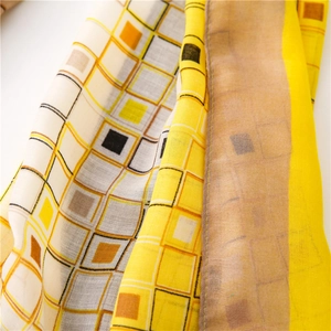 Détail macro du motif à carreaux géométriques colorés sur un tissu de foulard doux
