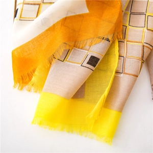 Détail d'une écharpe en lin à carreaux avec motifs jaunes et bordures effilochées