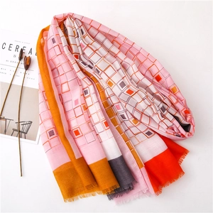 Détail du foulard à carreaux géométriques roses avec magazine sur fond blanc épuré
