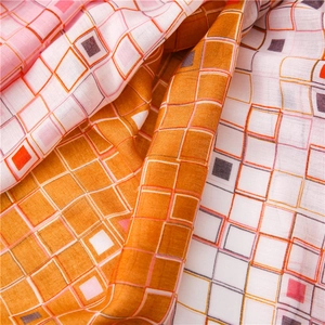Gros plan sur la texture du tissage serré et l'imprimé à carreaux colorés de l'écharpe