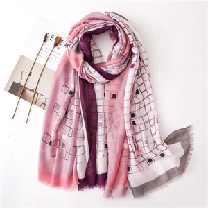 Détail d'une écharpe à carreaux géométriques rose et violet avec bords à franges