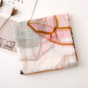 Detail of soft geometric print scarf with colorful patterns and delicate frayed edges