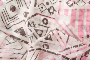 Detailed texture of white cotton linen scarf with geometric pink and black patterns