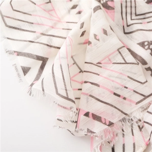 Detailed view of white cotton linen scarf with geometric patterns and frayed edges