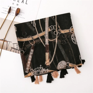 Detailed shot of black scarf with vintage gold chain print and fringe tassels