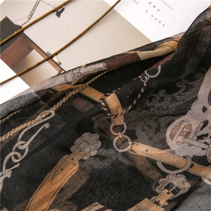 Detail of thin silk scarf with vintage harness chain print and horse bit metal buckle patterns