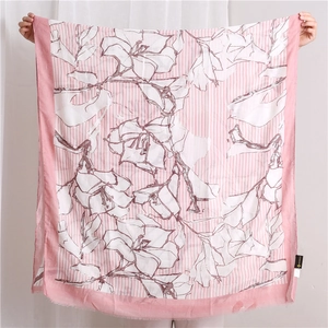 Dettaglio di sciarpa floreale rosa chiaro con motivi a fiori bianchi e strisce verticali
