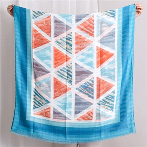 Detail view of cotton-linen shawl with blue geometric patterns and fringed tassel edges