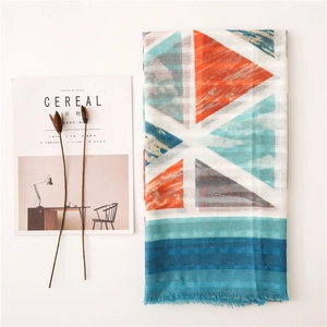 Flat lay of geometric cotton linen scarf with tassels next to Cereal magazine