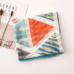 Detailed view of colorful geometric triangles and deep blue tassels on a cotton linen shawl