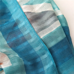 Detail view of light blue and white striped cotton linen scarf with fine edge stitching