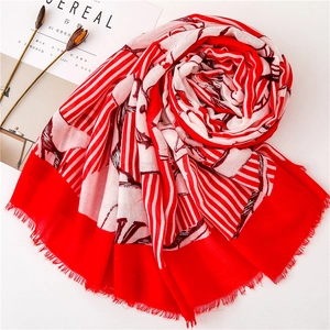Dettaglio della sciarpa in seta a righe rosse con piega floreale e bordi a frange