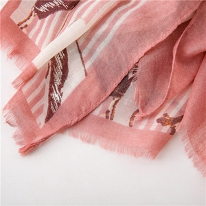 Dettaglio di sciarpa color rosa con motivo animale e bordi sfrangiati in vista macro