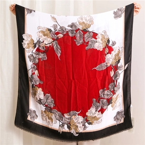 Detail of red floral print linen scarf featuring large circular patterns and fringe edges