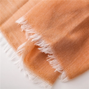 Makroaufnahme des orangen Leinenschals mit Textur und feinen Fransendetails