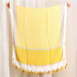 Detailed view of yellow and white bohemian cotton linen scarf with fringe and diamond patterns