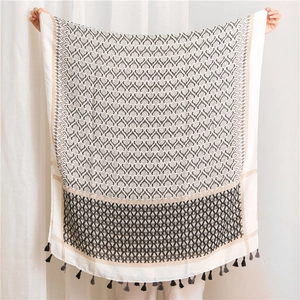 Detail view of cotton linen bohemian scarf with black geometric patterns and fringes