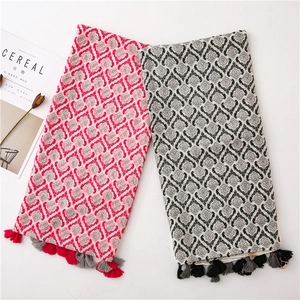 Detail of red and grey bohemian scarves with fringed tassels and woven texture