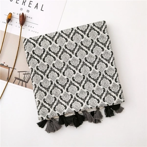 Detail of vintage bohemian cotton scarf with classic patterns and grey fringe tassels