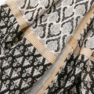 Macro detail of high-quality cotton linen scarf with vintage baroque print and gold tassels