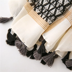 Close-up of bohemian linen scarf texture with ethnic prints and decorative tassels
