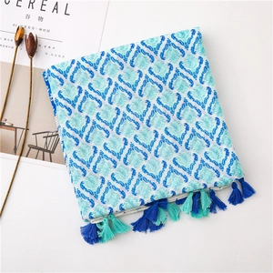 Detail of bohemian cotton linen scarf with blue ethnic patterns and fringed edges