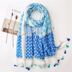 Detail of bohemian cotton linen scarf with geometric floral patterns and blue tassels