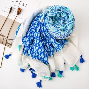Detailed view of bohemian blue floral cotton scarf with decorative fringe tassels