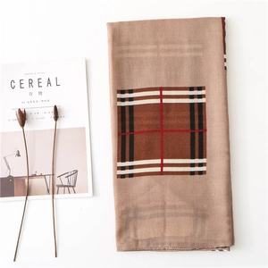 Flat lay of brown plaid cotton linen scarf with soft texture and warm grid patterns