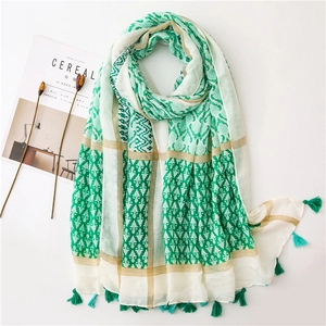 Flat lay of green cotton linen scarf with geometric prints and tassel edge detailing