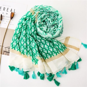 Detail view of cotton linen scarf showing bohemian patterns and turquoise tassel edges